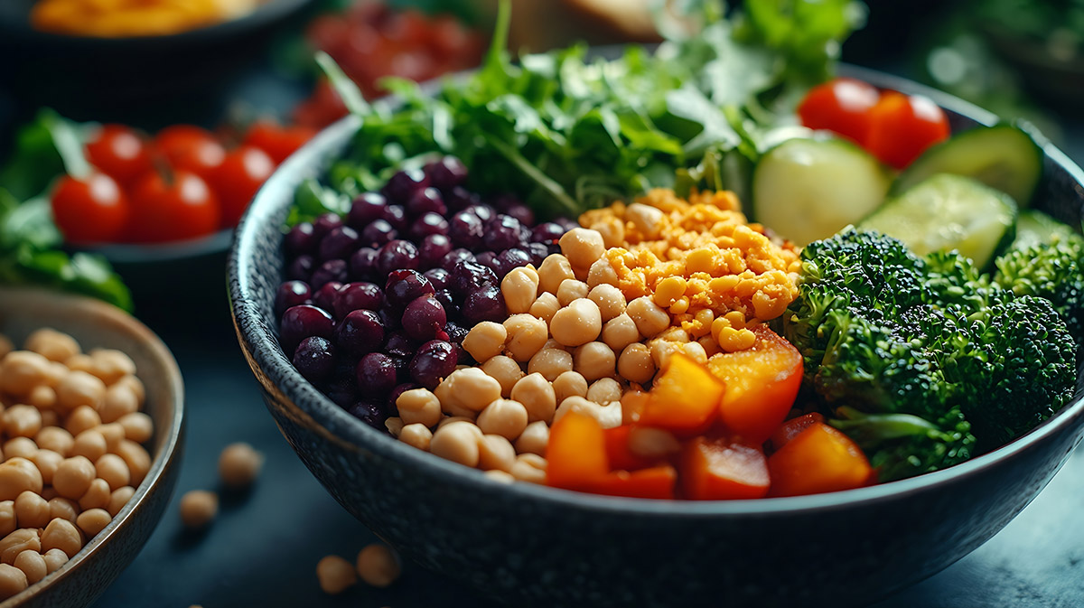 A colorful assortment of vegetables in a bowl, featuring beans, broccoli, and various other fresh vegetables.