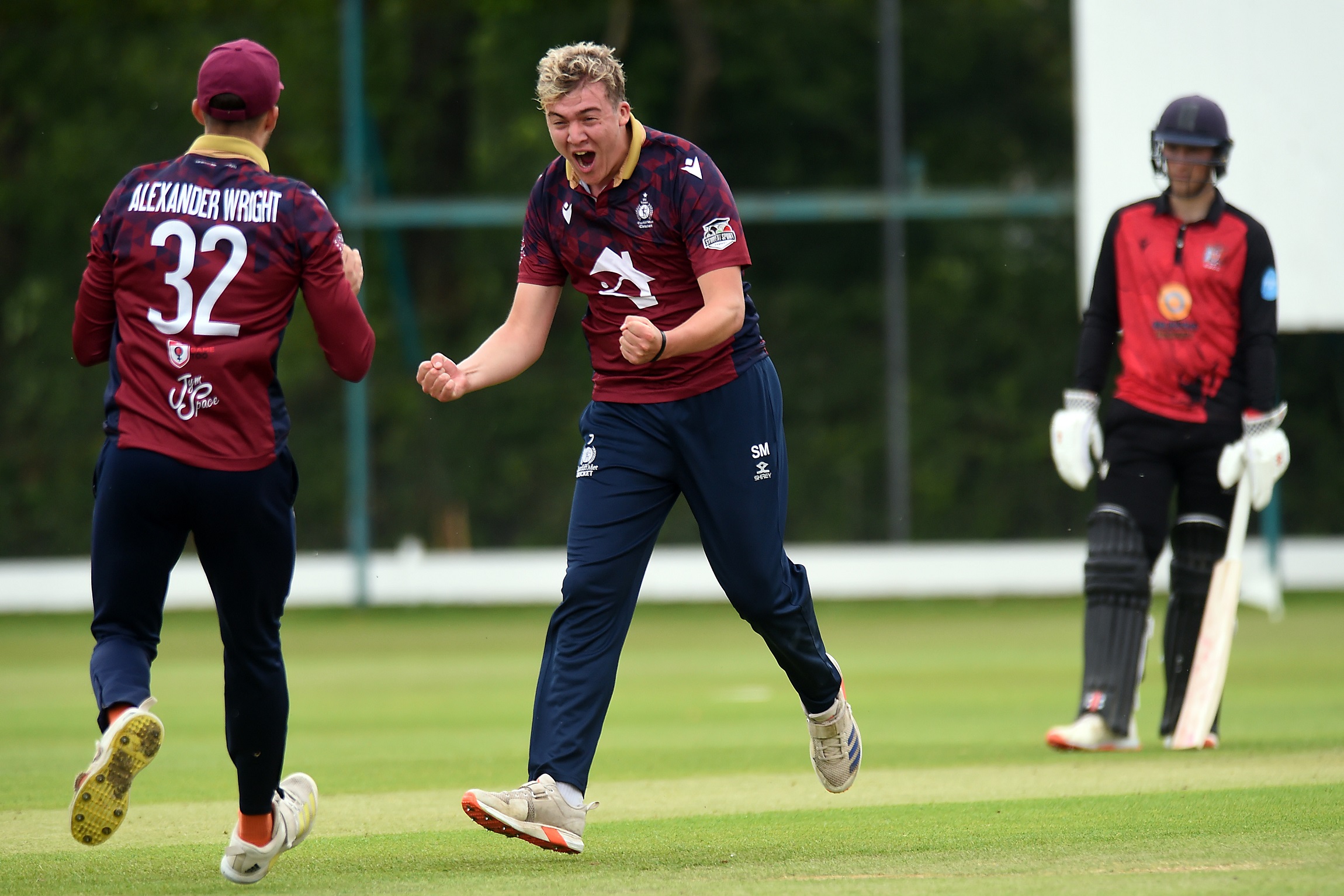 Two Cardiff Met cricket players celebrate as they run toward each other